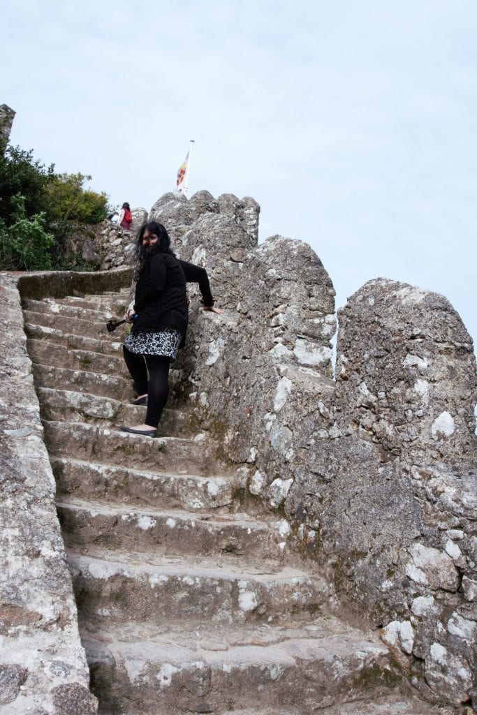 Anisa climbing up the castle walls. You can see how windy it was, I couldn't keep the hair out of my face. - "Why I Loved the Moorish Castle" - Two Traveling Texans