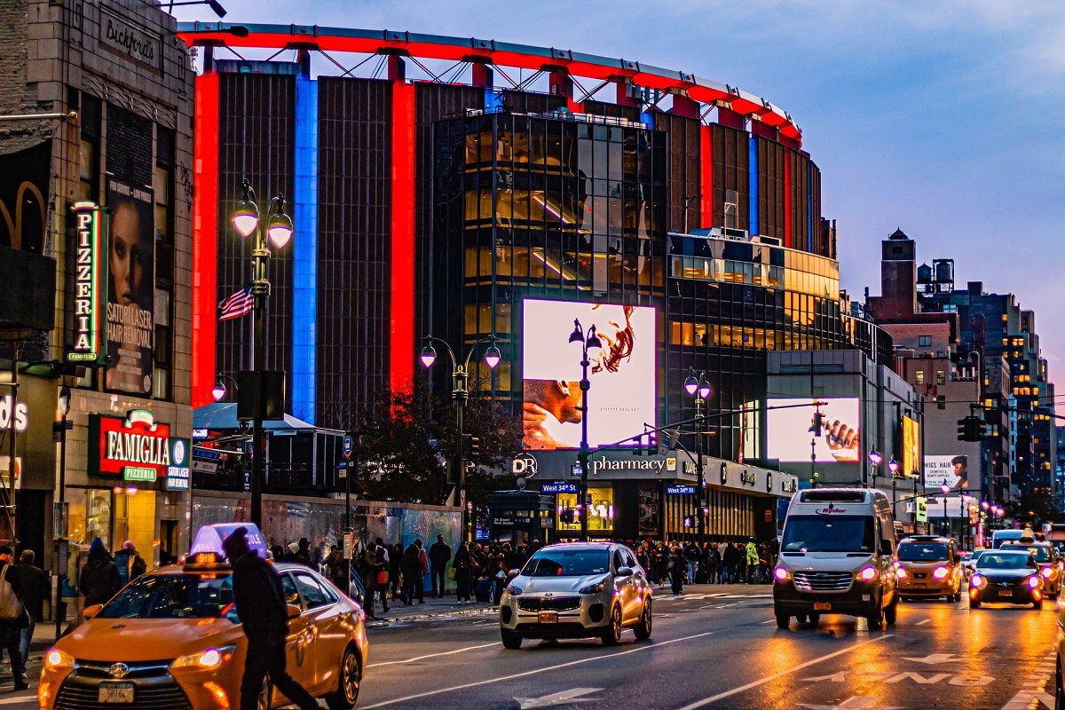 exterior of madison square garden in new york with cars driving past it