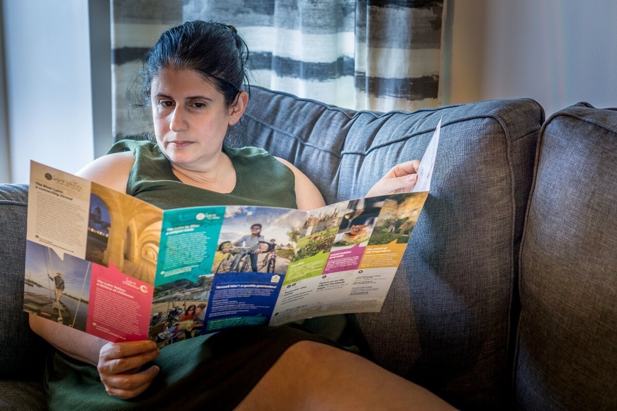 Anisa reading a travel brochure at home