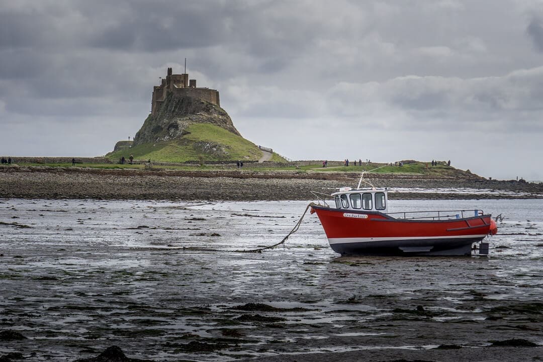 holy island castle with a boat in the foreground
