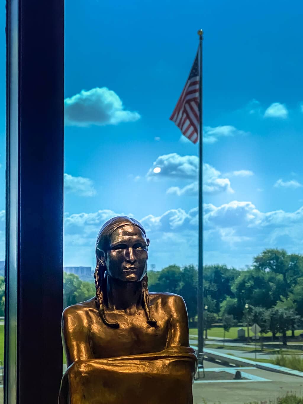 native american sculpture with american flag in the background at the amon carter museum in fort worth