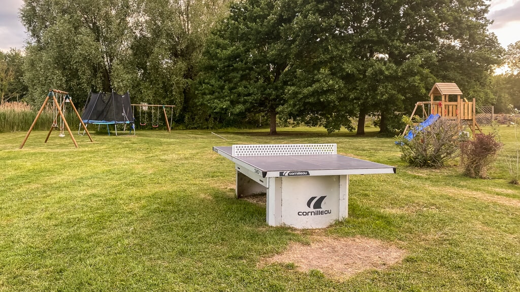 ping pong table, swings, trampoline, and playground equipment at the hotel du golf de l'ailette