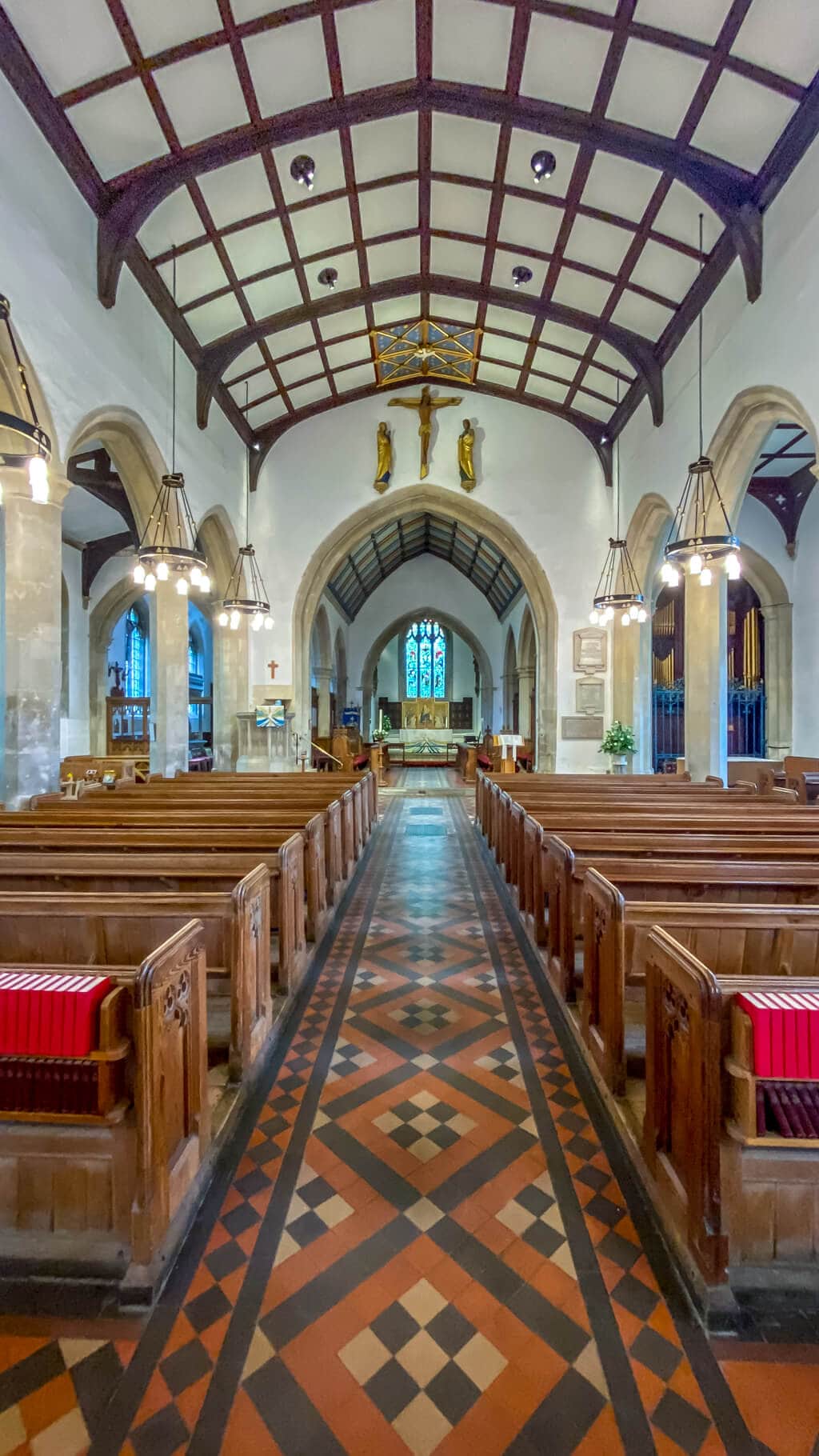 interior of st marys church - pews, floor with interesting design, and ceiling with wood beams