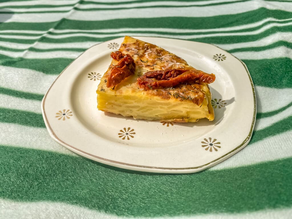 spanish tortilla slice on a plate on the picnic basket