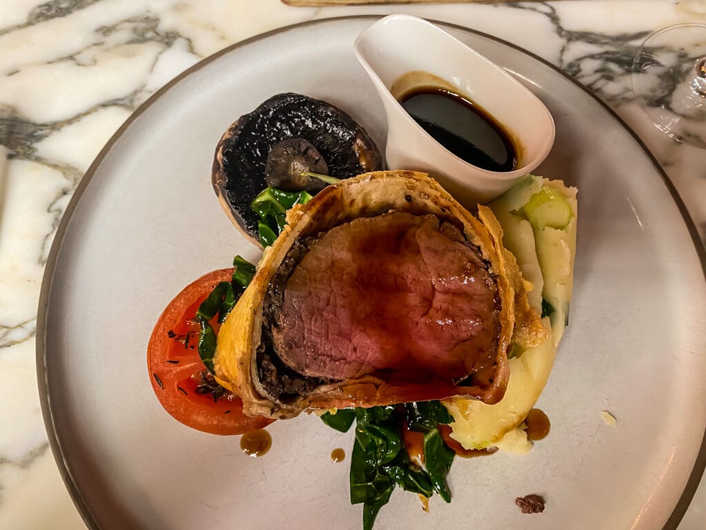 plate of beef wellington served at the lygon arms in broadway