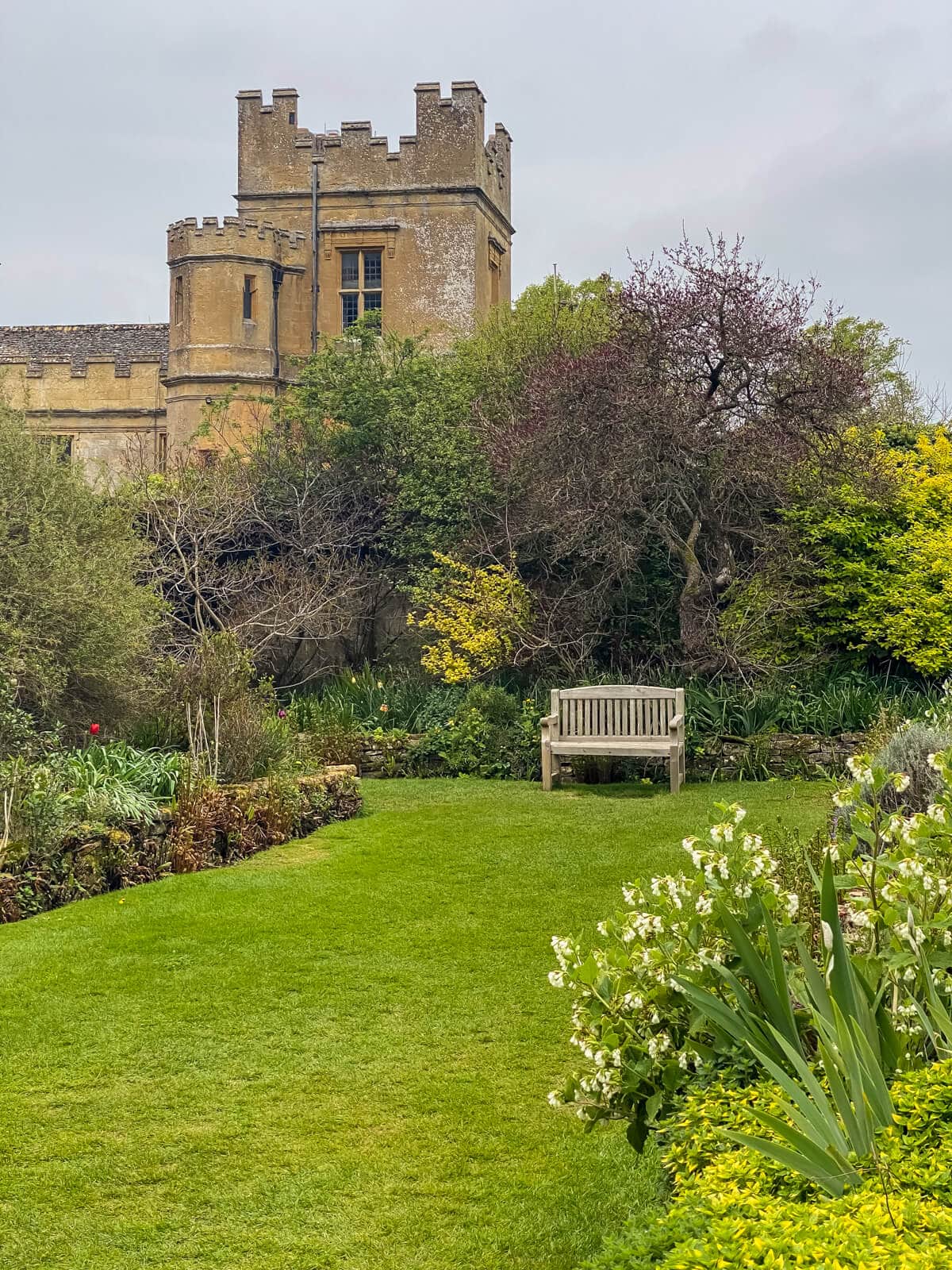 the secret garden at Sudeley Castle with view of a tower and a bench