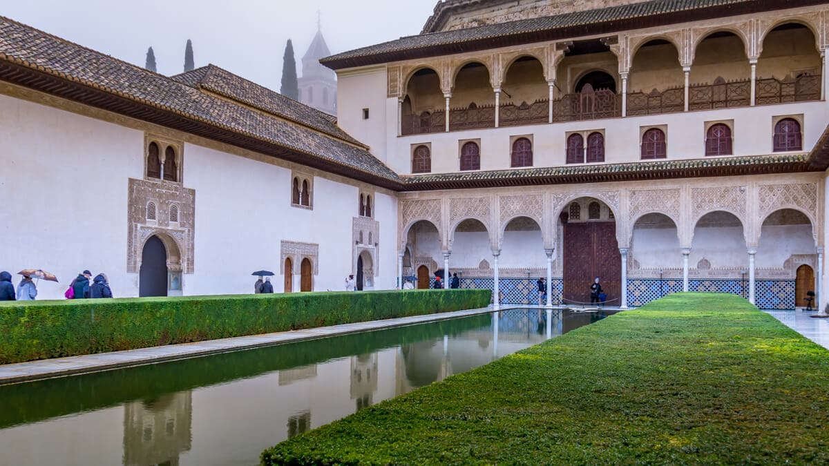 one of the courtyards in the nasrid palace with people in it