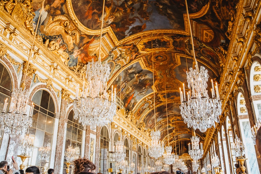inside the hall of mirror with beautiful chandeliers, paintings, and more