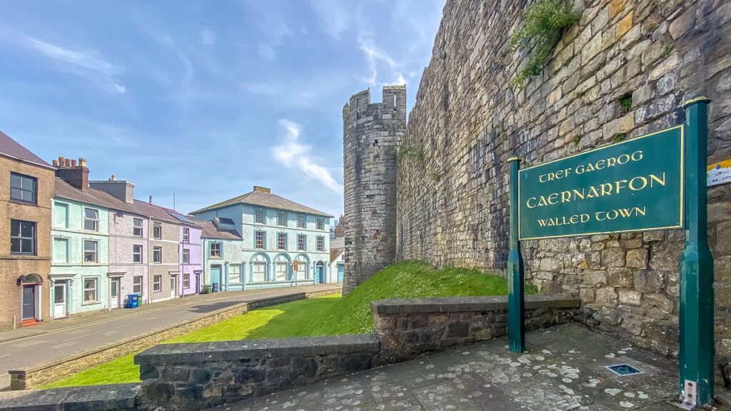 view of the town walls with a sign that says Caernarfon Walled Town